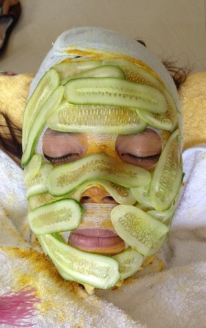 woman receiving cucumber facial treatment